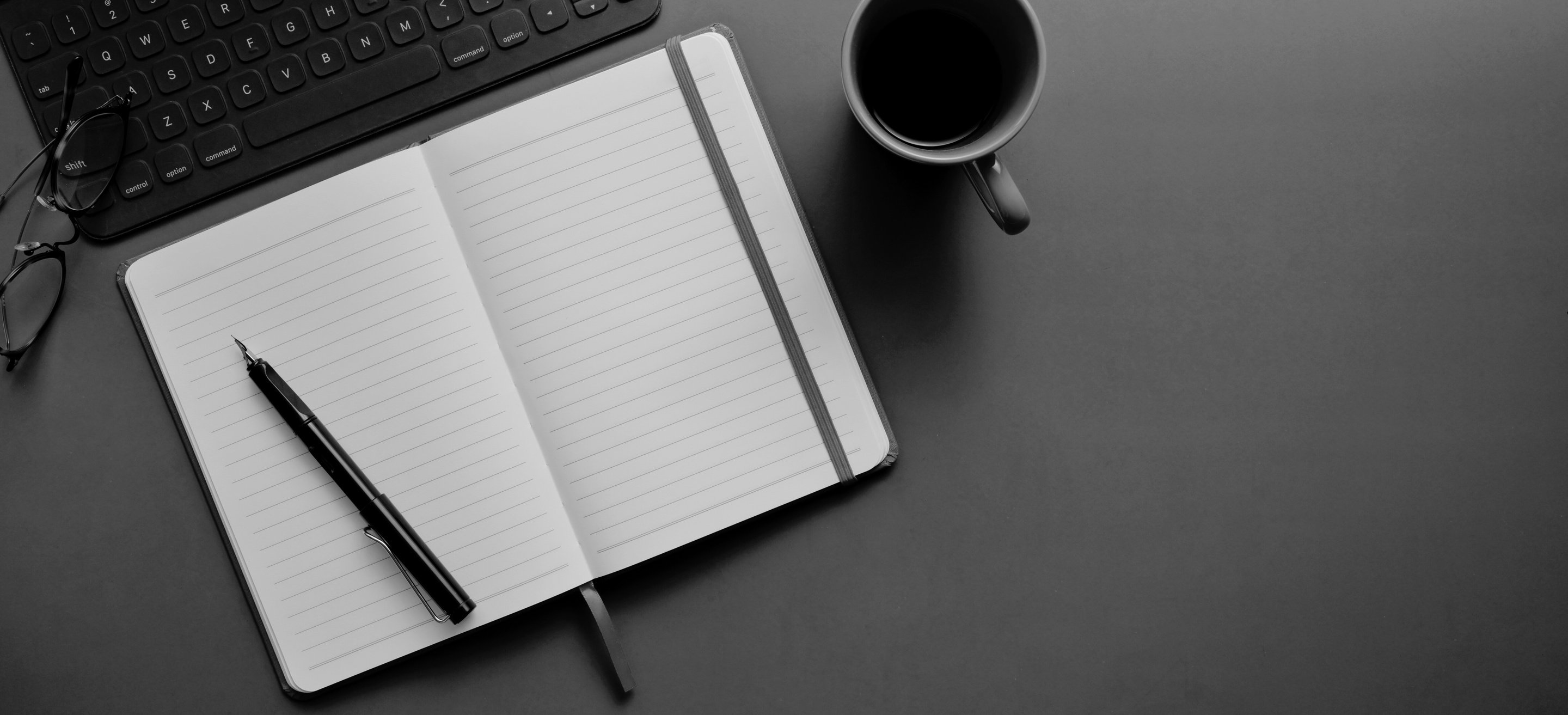 A black and white photo of an open notebook and a cup of coffee on a desk.
Get in touch via LinkedIn for more information on translation services.